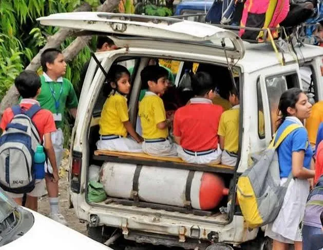 Children seated in the back of a school van directly above a large LPG gas cylinder